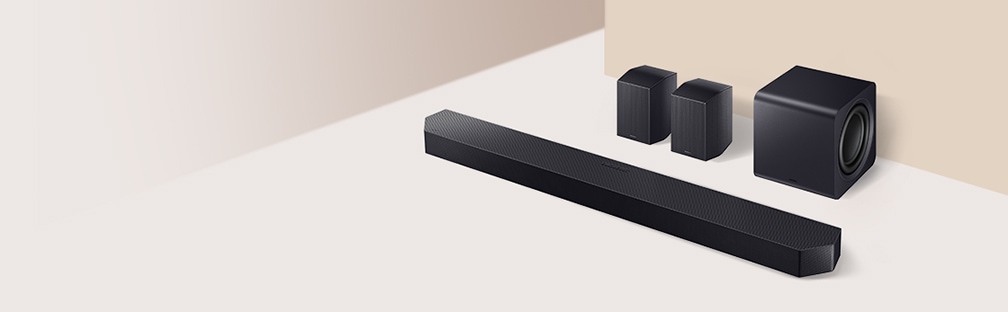 Na podłodze ułożony jest soundbar z subwooferem i dwoma tylnymi głośnikami.