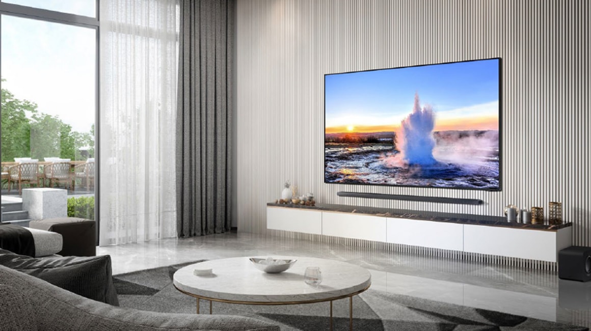 Widok na wiszący telewizor Samsung w minimalistycznym salonie z soundbarem za 1 zł