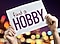 Trzymana w dłoniach kartka z napisem "find a hobby"