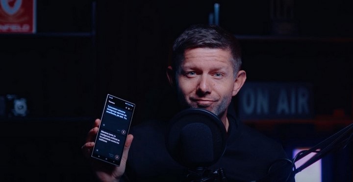 Zdjęcie przedsiębiorcy, który trzyma w ręku smartfon Galaxy AI.