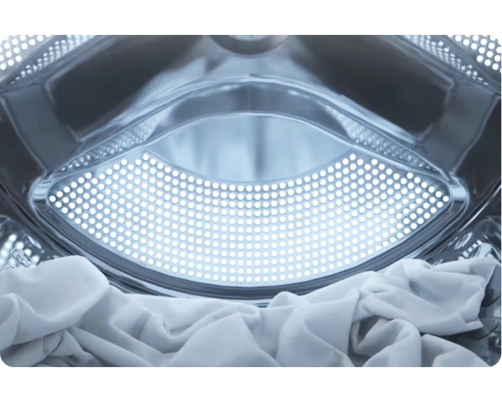 Wnętrze pralki z białymi ubraniami w środku