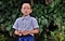 الصبي الصغير الشخصية الرئيسية في فيلم Kids of Paradise مرتديًا الزي المدرسي، يقف أمام الأشجار.