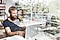 Uma fotografia com dupla exposição de um homem sentado a uma mesa com o seu portátil. Vê-se uma estante com livros em fundo