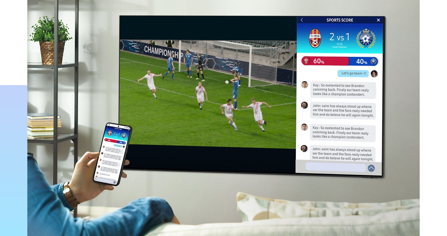 Uma pessoa é vista a verificar os resultados desportivos no seu smartphone enquanto desfruta de um jogo de futebol no ecrã dividido da sua Smart TV Samsung. A funcionalidade de ecrã dividido permite-lhe fazer várias tarefas e manter-se atualizado sobre as últimas actualizações desportivas enquanto assiste ao jogo de futebol no ecrã grande. O conteúdo do seu smartphone muda e ele participa numa videochamada animada com os seus amigos. Um dos ecrãs divididos na Samsung Smart TV espelha agora o conteúdo do telemóvel, alargando a experiência da videochamada ao ecrã maior da TV.