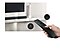 Una mano utiliza un control remoto para encender el televisor o la barra de sonido con un clic.