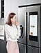 A woman reviews Meal Planner from the Family Hub display in the kitchen.