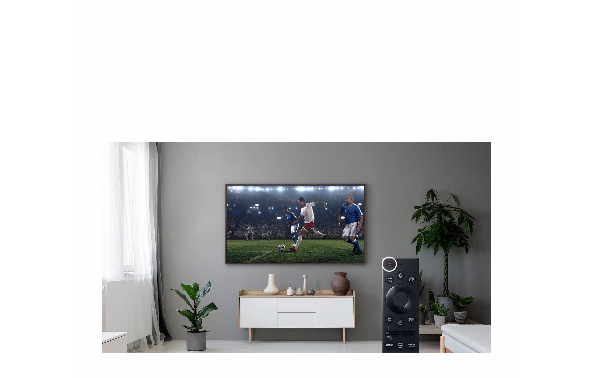 The Frame montat pe perete se află deasupra unei piese de mobilier decorativ și prezintă un meci de fotbal