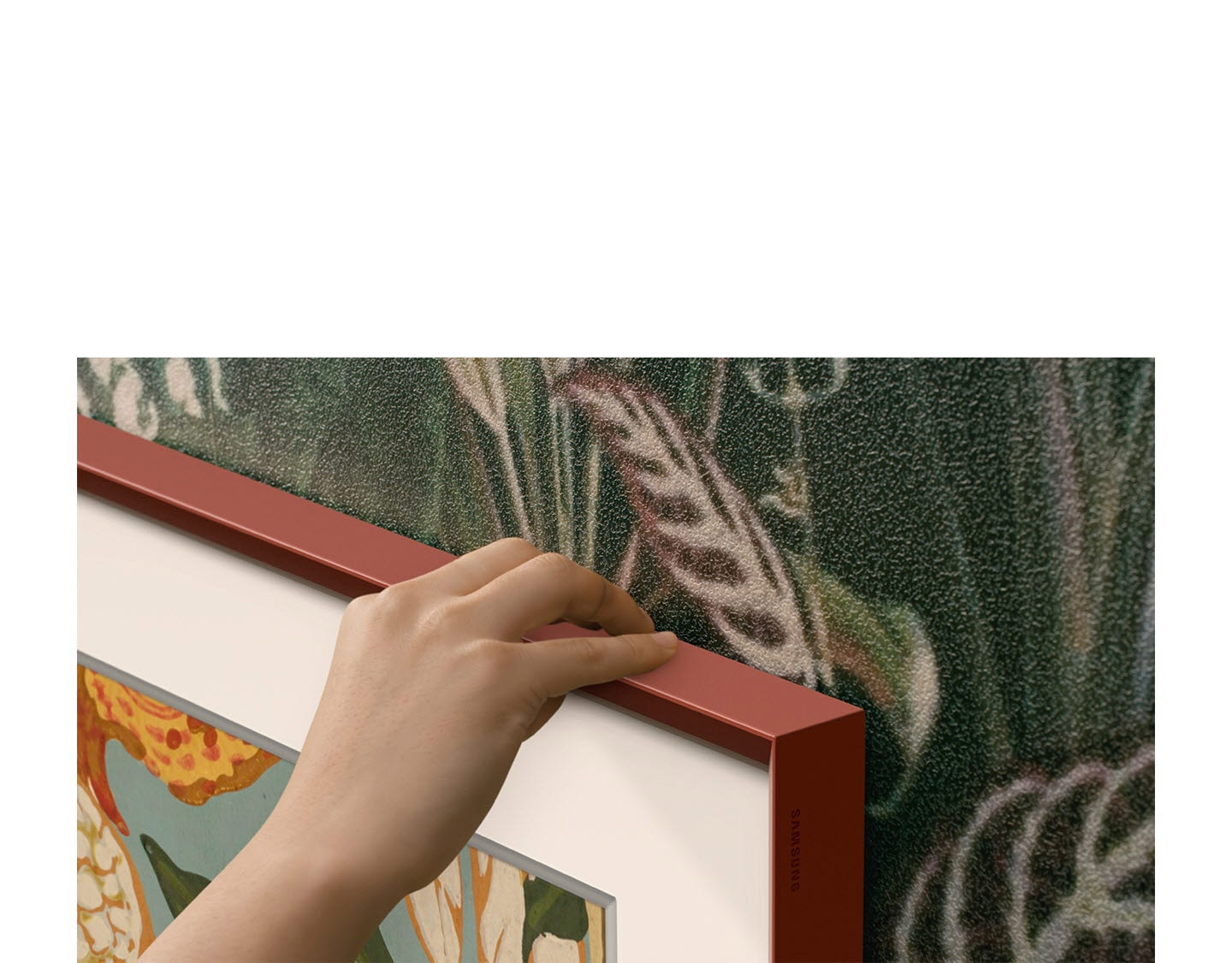 Imagine apropiată a colțului televizorului, care evidențiază culoarea Brick Red a cadrului care poate fi personalizat.