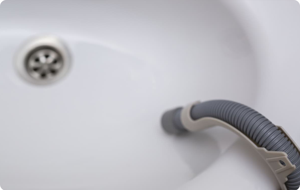 Конец шланга опущен в раковину