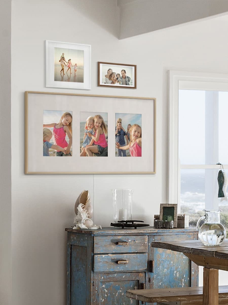 Рамка с тремя фотографиями в формате Squareslayout, висящая на стене в столовой.