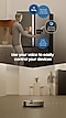 A man stands in front of a refrigerator and says Hi Bixby, how much time is left on the wash? Bixby activates, indicated by a logo on the washer's screen. It says 25 minutes left on the AI Wash course. The man says Finish the mop cleaning by that time! Use your voice to easily control your devices. Below, a Jet Bot cleaner moves through the kitchen cleaning while the man stands watches in the background.