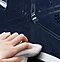 Hand wiping down oven interior.