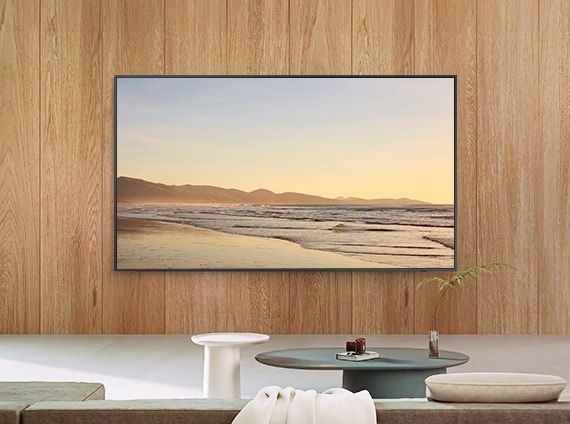 Installed on the wall of a living room, The Frame displays a peaceful scene of a seashore.