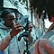 Photographer Karl Shakur adjusts his camera in a tripod before photographing a model during blue hour.