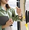 En kvinna står till vänster i bild. Till höger finns en kortläsare för kollektivtrafiken. Hon håller en tablet i sin högra hand och håller Galaxy Watch på sin vänstra handled mot maskinen.