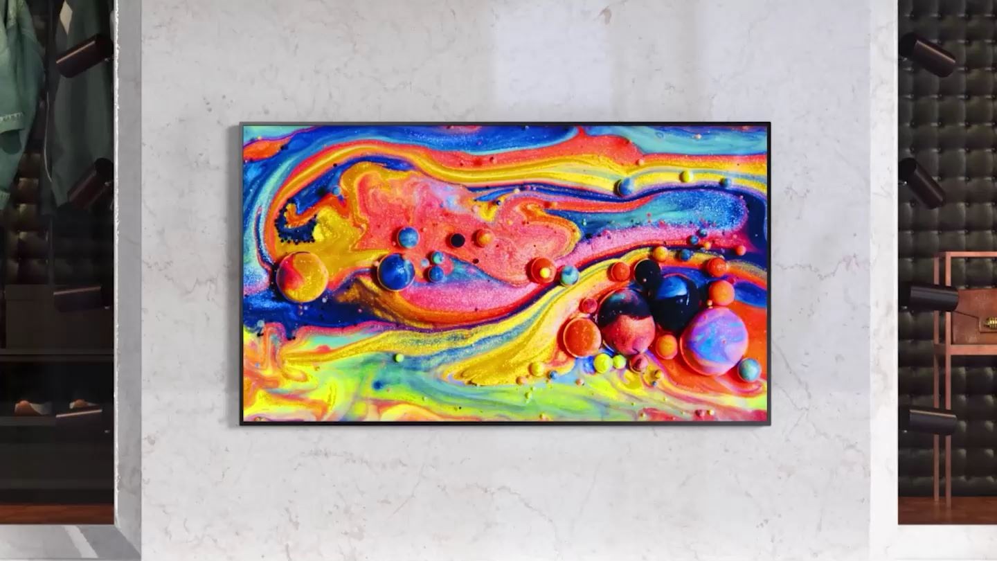 The colorful paints are zoomed out and displayed on the screen of QxB. The screen changes to the shape of the bag lying on it. There is a chip in the middle on a natural background, and the Quantum Processor 4K text comes out largely. The Samsung Quantum Processor 4K chip appears to change the natural scenery and cosmetic advertisement images more clearly. QxB is installed on the wall of the lobby, and the Floor Guide is coming out.