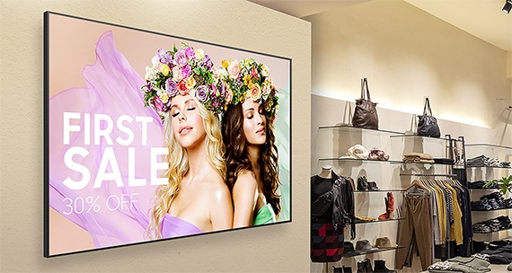 En kvinna tittar på flyginformation via Samsung UHD 4K -skyltar, QHR på flygplatsen.