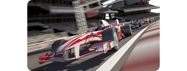 Racerbil i vitt och rött visas på racerbana. Suddig polmarkör i bakgrunden indikerar dess hastighet. 3 andra racerbilar följer precis bakom den.