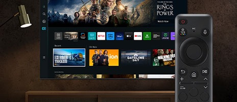 SolarCell Remote presenteras tydligt. Bakom fjärrkontrollen finns en Samsung TV som visar Smart Hub-startskärmen.