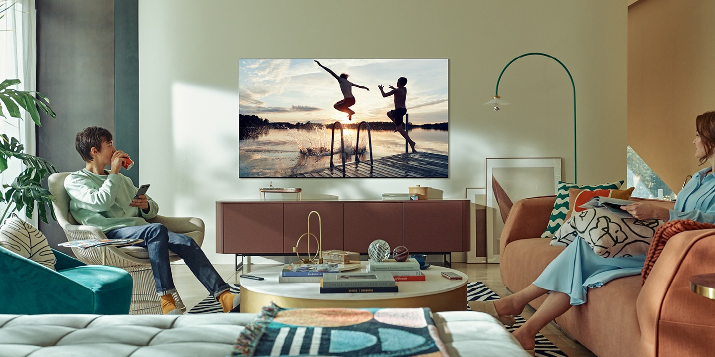 En QLED TV med en strand och moln på himlen på skärmen.