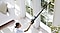 A woman vacuums a high windowsill with a Bespoke Jet™.