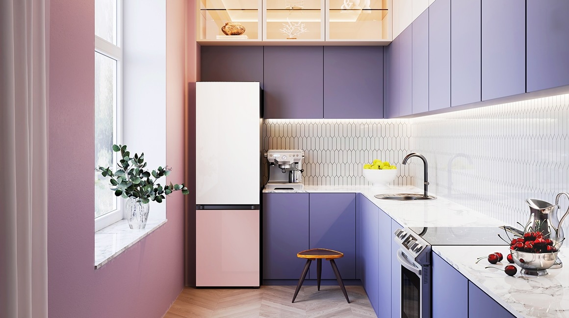A 2-door Bespoke refrigerator with Glam White panel on top and Glam Pink panel on the bottom is in a stylish white and purple themed kitchen next to a window.
