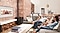 A family on sofa in the living room is watching family photos displayed on a wall with Samsung Ambient Mode to enjoy family memories.