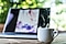 Coffee break: a hot cup of coffee in front of a laptop