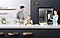 A father and daughter prepare eggs and orange juice on the kitchen counter, as the mother watches over them and smiles while standing next to the Family Hub with the screen in on mode.