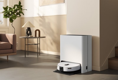 Samsung Jet Bot Combo robot vacuum docked at the Clean Station in a modern living room.