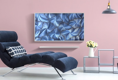 A stylish living room featuring a Samsung Smart TV displaying an artistic blue leaf pattern on the screen.