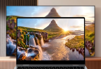 Laptop displaying a scenic landscape mirrored on a large Samsung Smart TV.