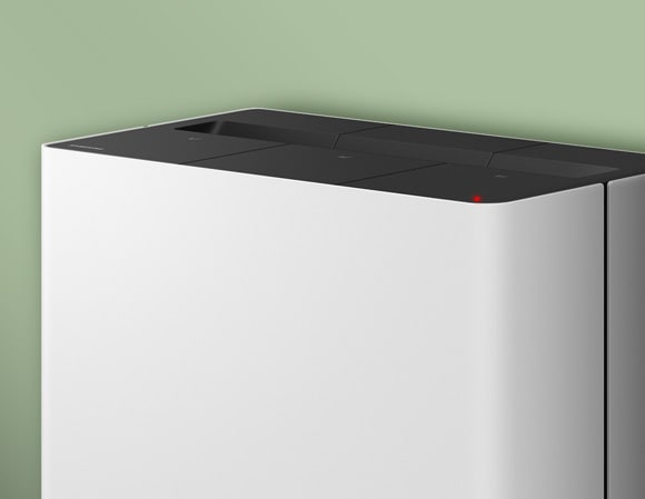 Close-up of the top of a white Samsung Clean Station with a red LED status indicator illuminated.