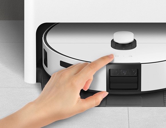 Close-up of a hand pressing a button on a Samsung Jet Bot Combo robotic vacuum cleaner.