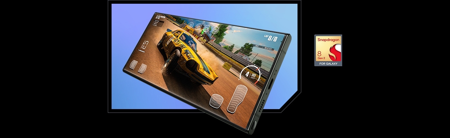 A Galaxy S23 Ultra which is seen from the right side at a slight angle shows an in-game scene of a car racing game on its screen. To the right is the Snapdragon® 8 Gen 2 processor logo, indicating the Galaxy S23 Ultra's powerful performance.