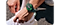 A pair of hands are tying shoe laces. The left hand has the Galaxy Watch7 on its wrist.