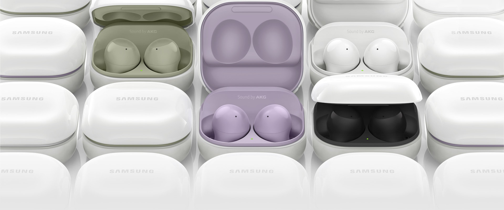 Galaxy Buds2 cases are placed next to each other. Several of the cases are opened, each showing different colours of the inside case, from olive, lavender, white, to graphite.