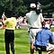 A Golf tournament is shown with the backs of three golfers in view