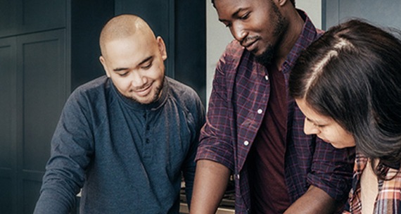 Image of a two males and a female reviewing a notepad