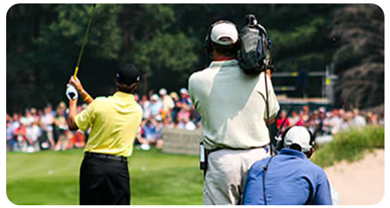 A Golf tournament is shown with the backs of three golfers in view
