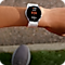 A point a view shot of wrist showing running statistics on a Samsung Galaxy smartwatch. The pavement is in the background.