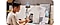 A man sat at desk taking photos on is Galaxy Smartphone