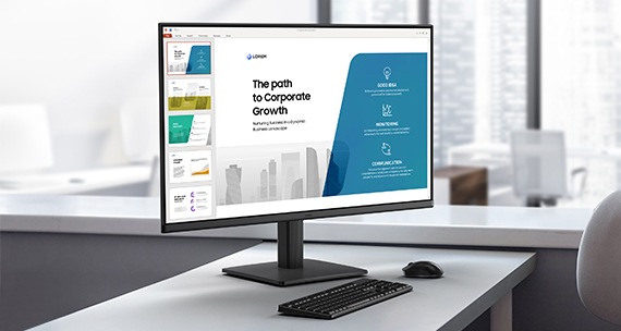 An office setup with a monitor displaying presentation slides.