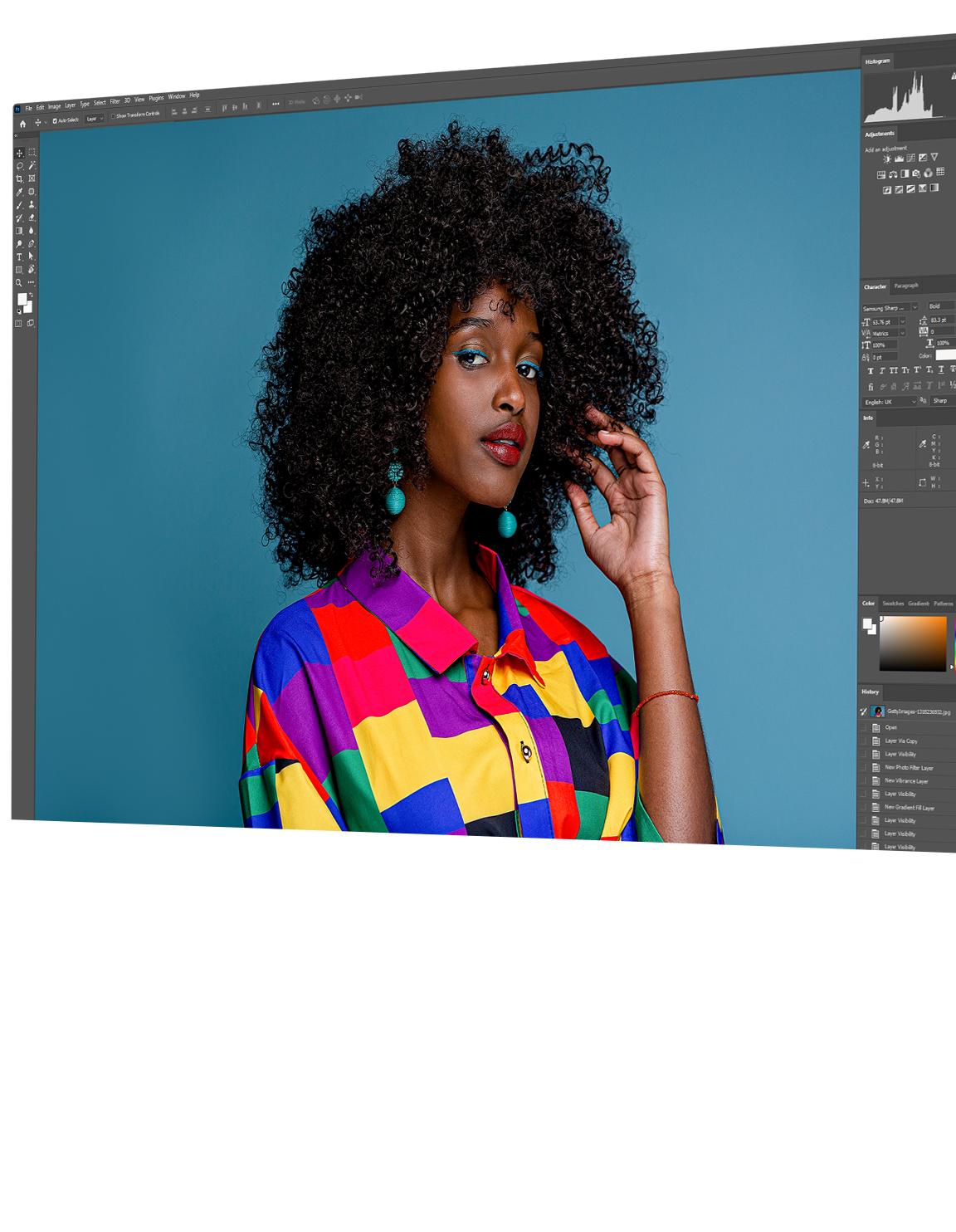 There is a photo of a model posing in front of a solid background on the monitor screen. The image is inside of a photo editing app with various editing tool options to the left and right of the photo.