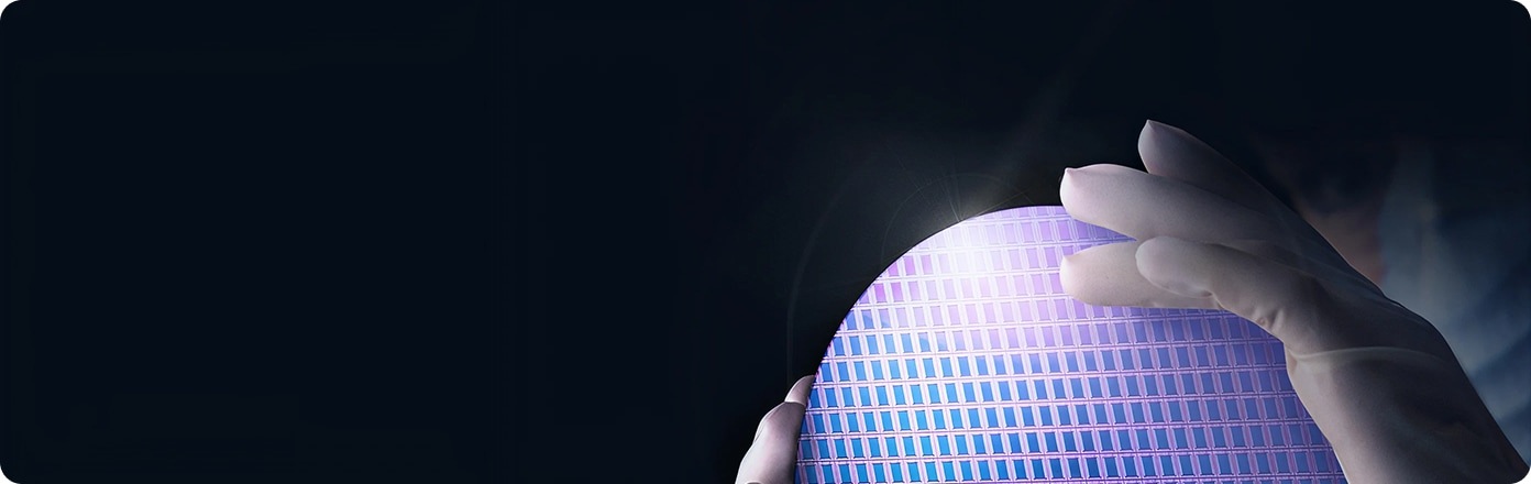 A man and a woman holding a tablet are standing at a mainframe computer and looking at the screen.