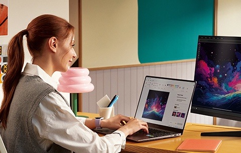 At a creatively-decorated office desk, a woman is using a generative AI tool on her Galaxy Book.