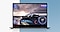 A graphite-colored Galaxy Book2 Pro 360 is opened. Onscreen is a racing game.