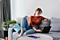 A woman in her living room works on her Samsung laptop
