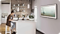 A woman sits at her counter in her kitchen working on a Samsung laptop