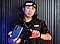 We see an out of focus man on a tablet in front of a white wall. Drex comes into focus and he looks up at camera and smiles. He says, "Hey, my name is Drex Lee. You guys might have seen my videos across the internet of me doing my epic one shots. I wanted to let you guys know that I'm an official Team Galaxy creative. That that means is that I get to unleeash my full potential using the full line of Samsung products. I can't wait for you to see what I do next. Hope you guys stay tuned"